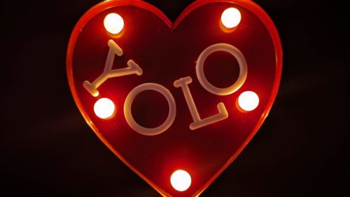 The acronym YOLO set in a heart with lights