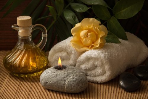 Candle, oil, towels and flower