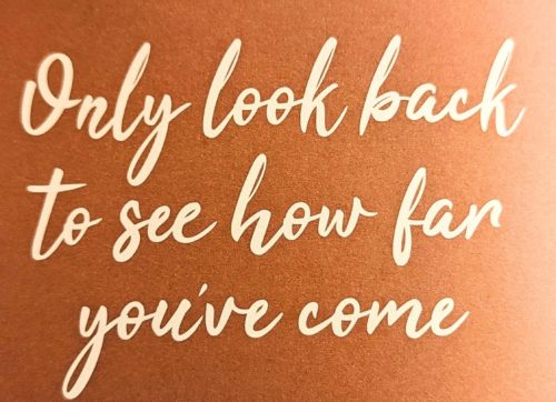 Words saying only look back to see how far you've come