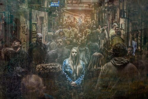 Woman standing highlighted in a crowd