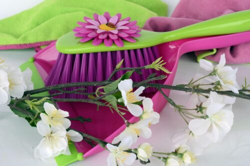 Spring cleaning - a dust pan and brush, cleaning cloths and flowers